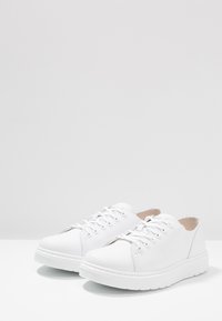 Sneakers in pelle bianca con punta arrotondata, dettagli di cuciture sottili, sei fori per i lacci e suola in gomma testurizzata.