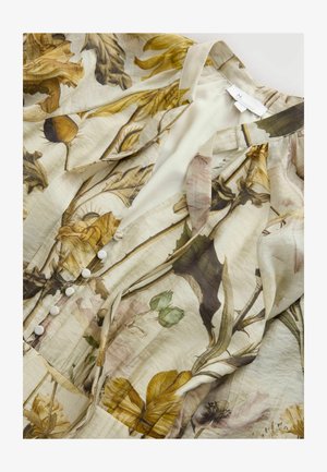 Bluzica s cvetnim vzorcem iz lahkih, teksturiranih materialov. Ima gumbasto zaponko spredaj, nežne barve in botanične ilustracije v rumeni in zeleni barvi.