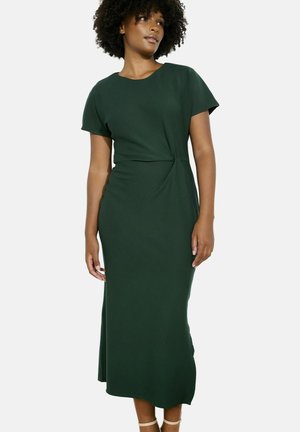 Dunkelgrünes, knielanges Kleid mit kurzen Ärmeln und einem gedrehten Frontdesign. Der glatte Stoff bietet eine weiche Textur ohne Muster oder Hardware.