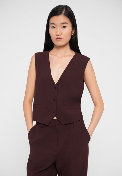 Burgundy tailored vest with a deep V-neck, sleeveless design, four front buttons, and side pockets, made of structured fabric.