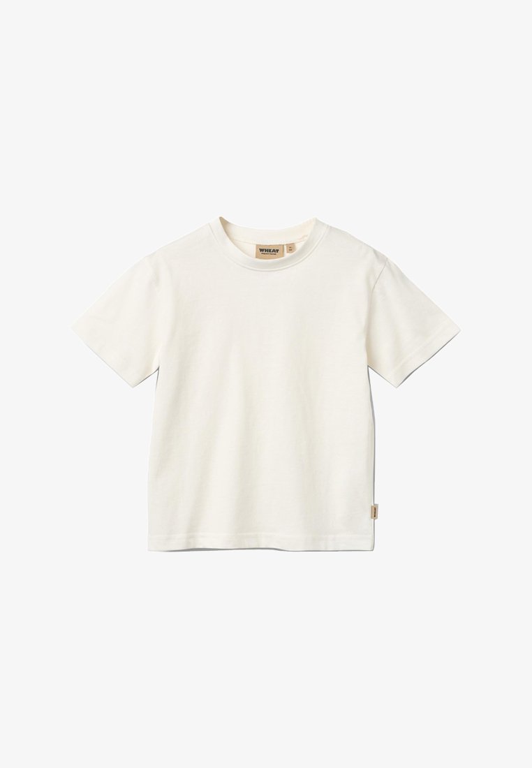 T-shirt blanc uni en coton à manches courtes avec col rond et une petite étiquette beige en bas à droite.