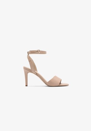 Beżowe sandały na wysokim obcasie z paskiem na kostkę, otwartym noskiem, gładką skórzaną teksturą i smukłym obcasem w kształcie szpilki.