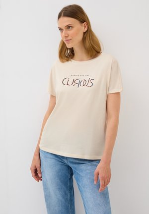 T-shirt en coton beige clair à manches courtes et col rond, avec un motif imprimé dans des couleurs sombres et claires.