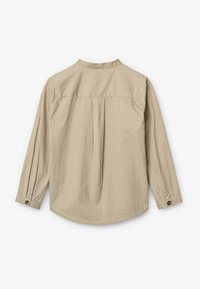Camicia beige a maniche lunghe con colletto alla cinese, dettaglio con piega sul retro, orlo arrotondato e polsini con bottone. Realizzata in tessuto morbido e leggero.