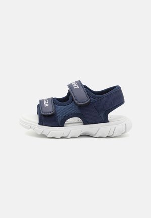 Sandales sportives bleu marine avec deux brides Velcro réglables, tige en mesh respirant et semelle extérieure en caoutchouc blanc avec profil texturé.