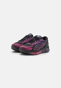 Black athletic shoes with purple and pink accents, featuring a mesh upper, textured sole, and prominent brand logo on the tongue.