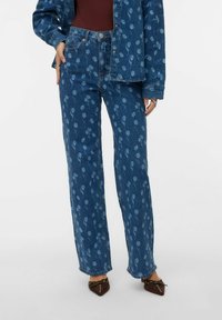 Niebieskie spodnie dżinsowe w kwiatowy wzór o prostych nogawkach. Posiadają pięć kieszeni, zapięcie na guzik oraz delikatne przetarcia.