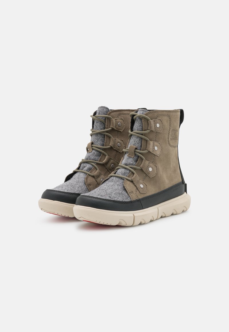 Stivale in suede marrone e feltro grigio con suola in gomma beige, sei occhielli e lacci grigi. Punta arrotondata e dettagli cuciti sulla parte superiore.