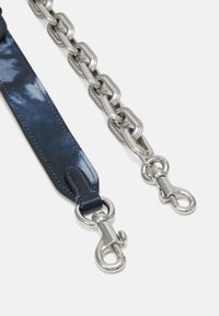 Bracelet en cuir bleu marine avec chaîne et fermoirs en métal argenté, présentant un motif embossé et une texture lisse. Les maillons de la chaîne sont ovales.