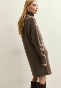 Bruine coltrui jurk met ribbelmanchetten en zoom, kniehoog, gemaakt van zacht materiaal, met een ontspannen pasvorm en een minimalistisch ontwerp.