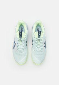 Lyse blå treningssko med teksturert mesh-overdel, hvite snører, marineblå detaljer og en neongul såle. Inkluderer ASICS-merke.