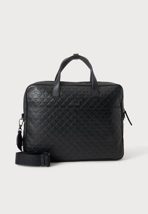 Serviette en cuir noir avec motif diamant embossé, poignées supérieures et bandoulière amovible sur un fond uni.