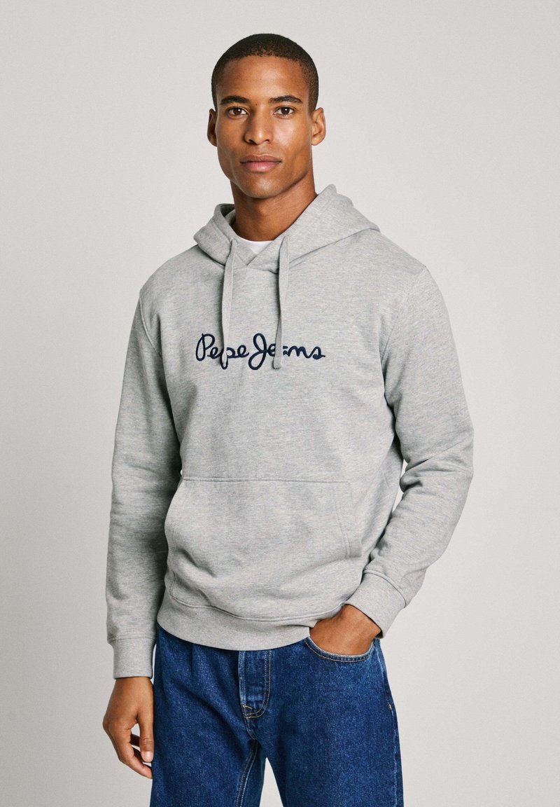 Lichtgrijze hoodie met een trekkoord, voorzien van een marineblauw geborduurd logo. Materiaal lijkt zacht; voorzak zichtbaar.