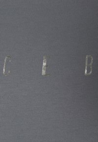 Grau gerippter Stoff mit reflektierenden Buchstaben "C E B", gefertigt in glatter Textur und vertikalen Linien.