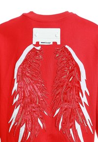 Sudadera roja con grandes alas bordadas en blanco y dorado, detalles texturizados y una etiqueta de marca en la parte trasera.