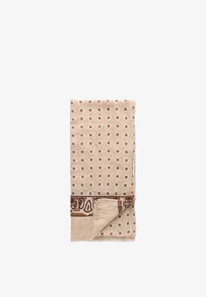 Beige tekstil med et gitter af små brune firkanter og en dekorativ brun kant med blomster- og paisleymønstre, foldet med et hjørne vendt.