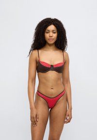 Σετ εσωρούχων καφέ και κόκκινο με πουά σχέδιο, με δομημένο σουτιέν και σλίπ, κόκκινες λεπτομέρειες και σκούρο περίγραμμα στις άκρες.