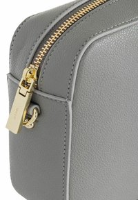 Borsa in pelle grigia con finitura texture, cerniera e accessori dorati. Presenta cuciture bianche lungo i bordi e una chiusura sicura.