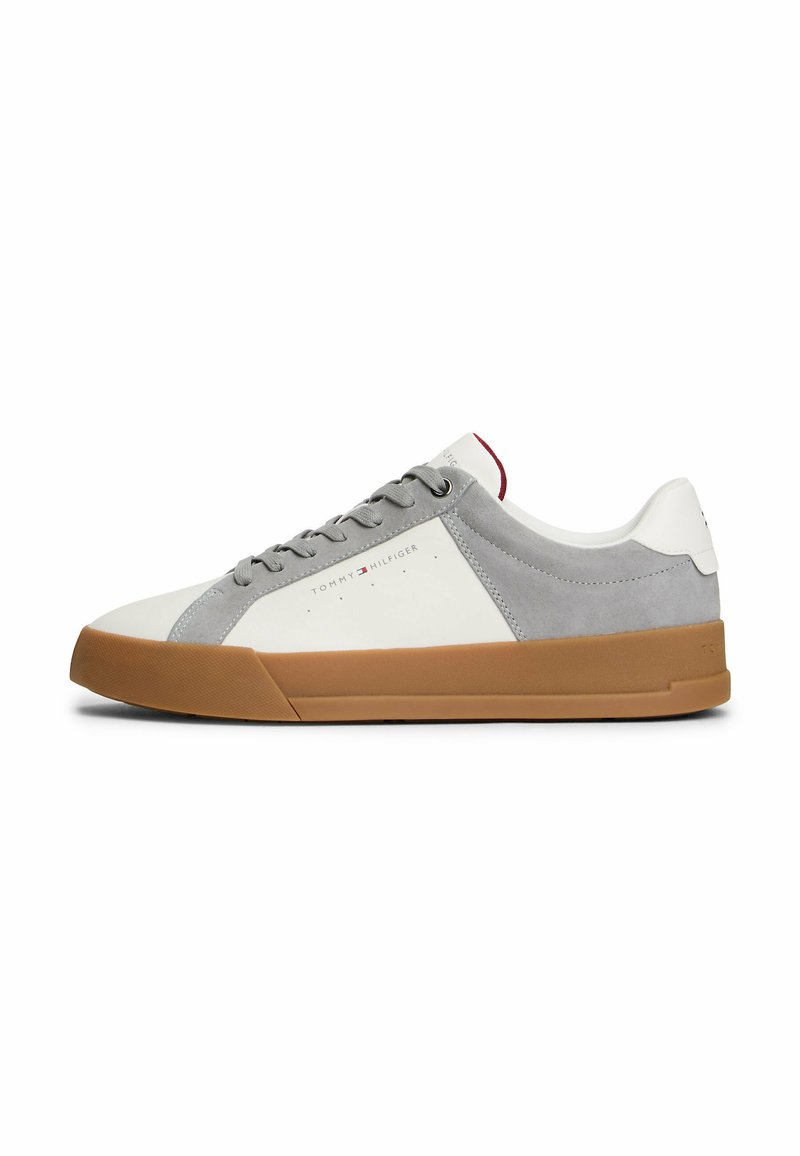 Sneaker bianca e grigia con materiali in suede e pelle, suola in gomma, punta rotonda, lacci piatti e dettaglio del logo di lato.