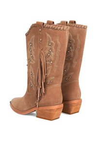 Botas de cowboy de ante marrón con costuras decorativas y tachuelas metálicas. Presentan detalles de flecos y un tacón apilado para mayor altura.