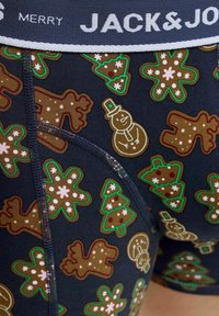 Blauwe boxershorts met een feestelijk patroon van peperkoekmannetjes, kerstbomen en sneeuwmannen in bruin en groen tinten. Witte tailleband.