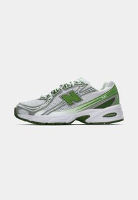 New Balance jooksujalanõud, millel on valgest ja rohelisest võrgust pealmine osa, pehme tallaga ja silmapaistva logosümboolikaga. Kujundatud mugavuse ja toe tagamiseks.