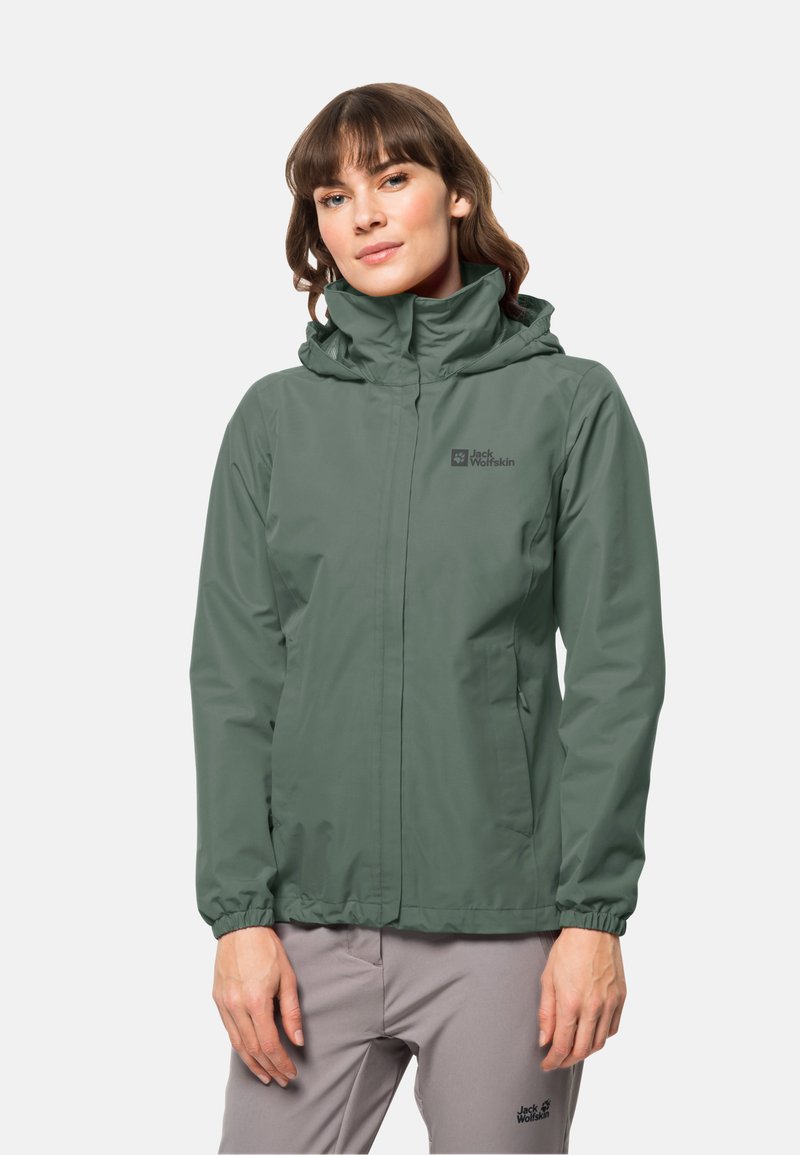 Veste imperméable verte avec un col haut et une capuche réglable, dotée de poignets élastiques et de poches latérales. Logo sur le côté gauche de la poitrine.