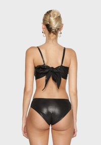 Černý bikiny set vyrobený z lesklého materiálu, který má zavazovací vršek a spodní část s nízkým pasem. Jednoduchý design s nastavitelými ramínky.