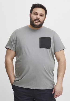 Grijze T-shirt met korte mouwen van katoen. Heeft een zwarte patch pocket op de linkerborst. Glad textuur en een ontspannen pasvorm.