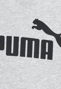 T-shirt in cotone grigio con grande testo nero "PUMA" e logo di pantera nera in corsa. Tessuto morbido con design classico a girocollo.