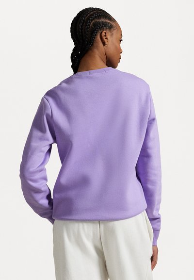 Levanduľový crewneck sveter s dlhými rukávmi, vyrobený z mäkkého materiálu, s uvoľneným strihom a minimalisticými detailmi šitia.