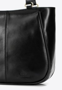 Czarna skórzana torebka o gładkiej fakturze, zaokrąglonym kształcie i kontrastowym ściegu. Zawiera wytłoczone logo na dole.
