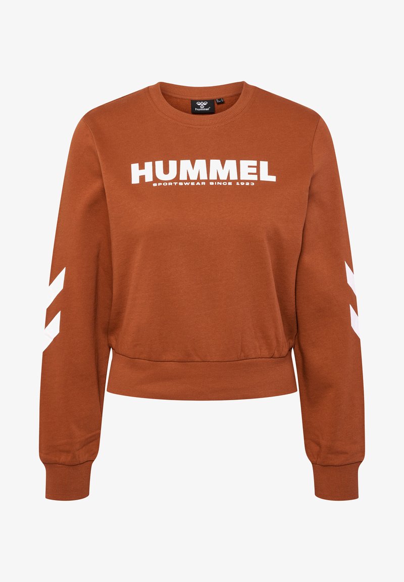 Rostfärgad sweatshirt med vit "HUMMEL"-logotyp och texten "SPORTSWEAR SINCE 1923". Funktioner vita chevron-accenter på ärmarna och ribbad nederkant.
