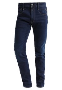 Mörkblå denimjeans med smal passform, traditionell femficksdesign, silverfärgad knapp och kontrasterande sömmar. Slät textur och rak ben.