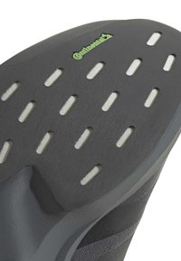 Σόλα παπουτσιού με μαύρο λάστιχο, άσπρες ορθογώνιες επενδύσεις λαβής και πράσινο λογότυπο Continental κοντά στο κέντρο της κορυφής.