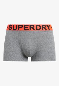 Boxer briefs a righe grigie con una vestibilità aderente. Larga fascia arancione in vita con la scritta nera "SUPERDRY" in evidenza.