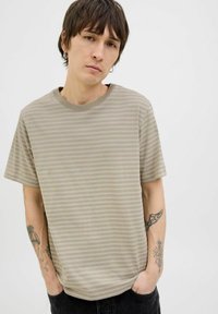Beige striped t-shirt with short sleeves and a round neckline. Made of cotton, featuring a soft texture and a relaxed fit.