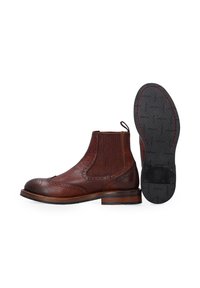 Hnědé kožené Chelsea boty s brogue detaily, elastickými postranními panely a poutkem. Silná gumová podrážka má texturovaný vzor a červené prošívání.