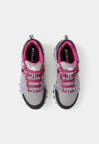 Paire de chaussures de sport grises et noires avec des lacets et une doublure intérieure roses, vues de dessus sur fond blanc.