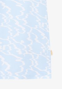Lichtblauwe stof met een golvend wit patroon, gemaakt van duurzaam materiaal met een gladde textuur. Inclusief een klein label met de merknaam.
