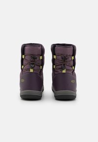 Bottes étanches violettes avec un dessus doux, un col rembourré, des lacets élastiques et des semelles en caoutchouc grises. Présente un logo en relief sur le côté.