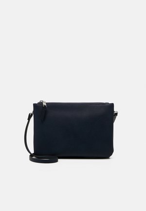 Kleine marineblauwe leren crossbodytas met een smalle verstelbare riem en een bovenste ritssluiting tegen een effen achtergrond.