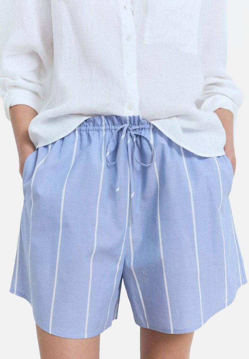 Shorts bleu clair à cordon de serrage avec des rayures blanches verticales, dotés d'une taille élastique et de poches latérales. Fabriqués dans un tissu doux et respirant.