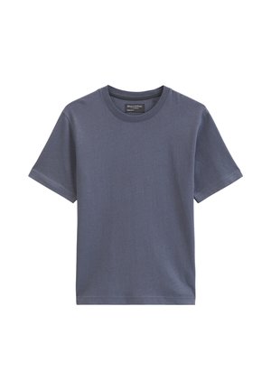 T-shirt uni à manches courtes et col rond en bleu pâle avec une petite étiquette de marque noire à l'intérieur du col.