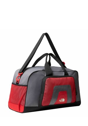 Borsa a duffel grigia con tasche e dettagli rossi in rete, manici superiori doppi e una tracolla rimovibile. Tessuto resistente con una finitura testurizzata.