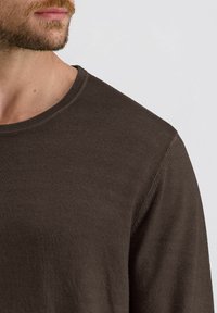 Braunes Langarmhemd mit geripptem Ausschnitt. Der Stoff erscheint glatt und leicht und präsentiert ein einfaches, klares Design.