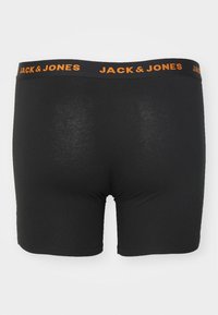 Schwarze Boxershorts mit weicher Textur, ausgestattet mit einem breiten schwarzen Bund, auf dem "JACK & JONES" in Orange gedruckt ist. Einfaches, tailliertes Design.