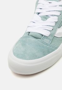 Baskets en suède bleu clair avec des lacets blancs. Présentent une semelle en caoutchouc blanc texturé et des détails de couture le long de la tige.