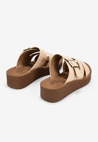 Sandalias beige con tiras de textura de cocodrilo y una hebilla dorada sobre una suela de plataforma marrón, similar al corcho. Forro interior suave para mayor comodidad.