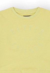 Sudadera de cuello redondo de color amarillo claro con texto en relieve "Mejores Amigos Casa Canadá" en un patrón circular en el pecho.